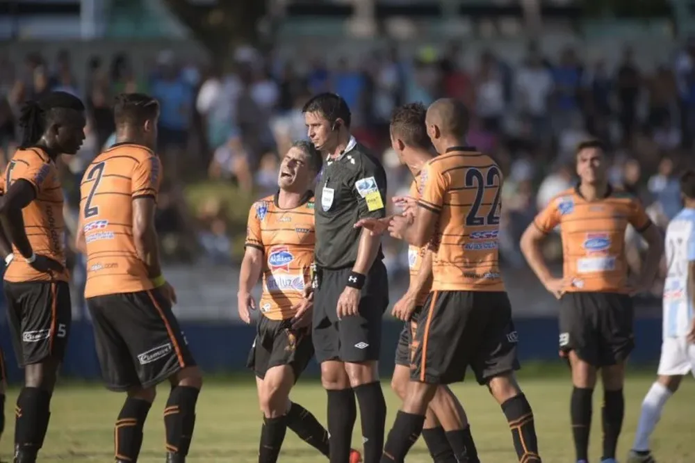 El árbitro Jonathan Fuentes recibe el reclamo de los jugadores de Sud América