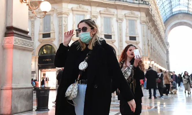 Una mujer con tapaboca camina en la galería Vittorio Emanuele II de Milan