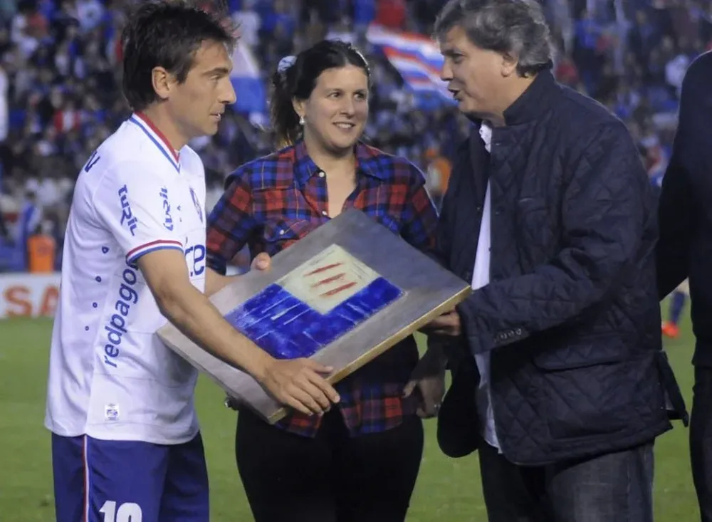 María Laura Muxi y Pablo Durán, entregan a Martín Ligüera, una placa recordatoria, por los 100 partidos con los camiseta de Nacional