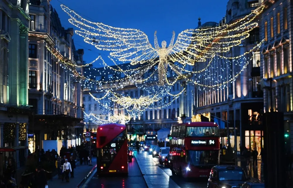 La gente y el tráfico suben por Regent Street debajo de las luces de Navidad en Londres, Gran Bretaña.