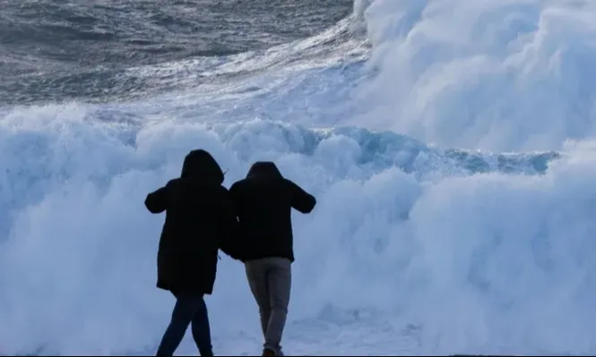 Dos turistas observan el oleaje en la costa de Muxía, este miércoles en A Coruña. (Archivo)