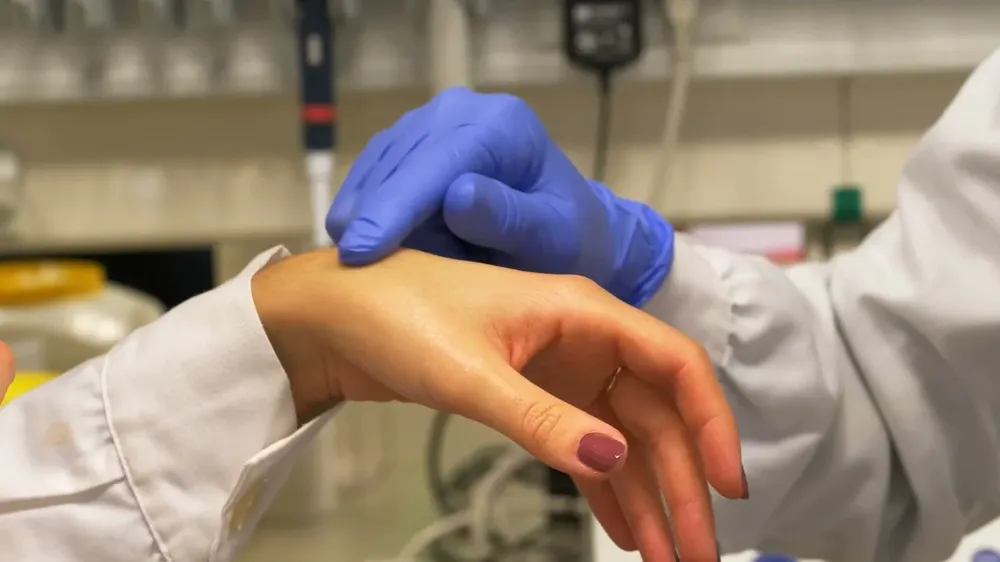 Manos médico echando crema.