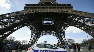 Un coche de policía estacionado frente a la torre Eiffel, en Francia, Paris