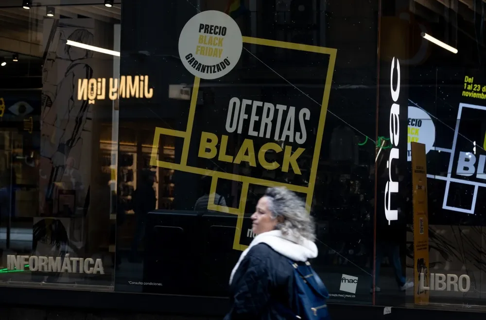 Una persona pasa por delante de una tienda que anuncia un cartel publicitario del ‘Black Friday’.