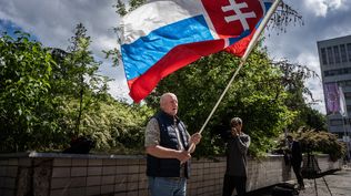 Atentado: un hombre sostiene una bandera de Eslovaquia; llegó a orar frente al hospital en Banska Bystrica, Eslovaquia, donde el primer ministro eslovaco, Robert Fico, está siendo tratado.