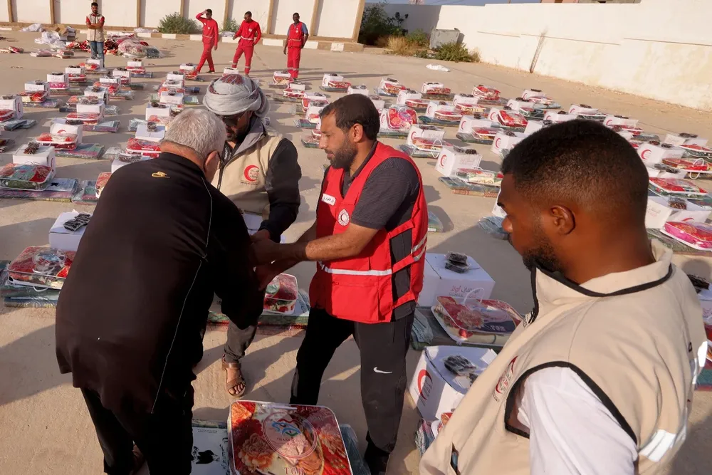 Miembros de la Media Luna Roja distribuyen alimentos y medicinas entre los damnificados en Libia
