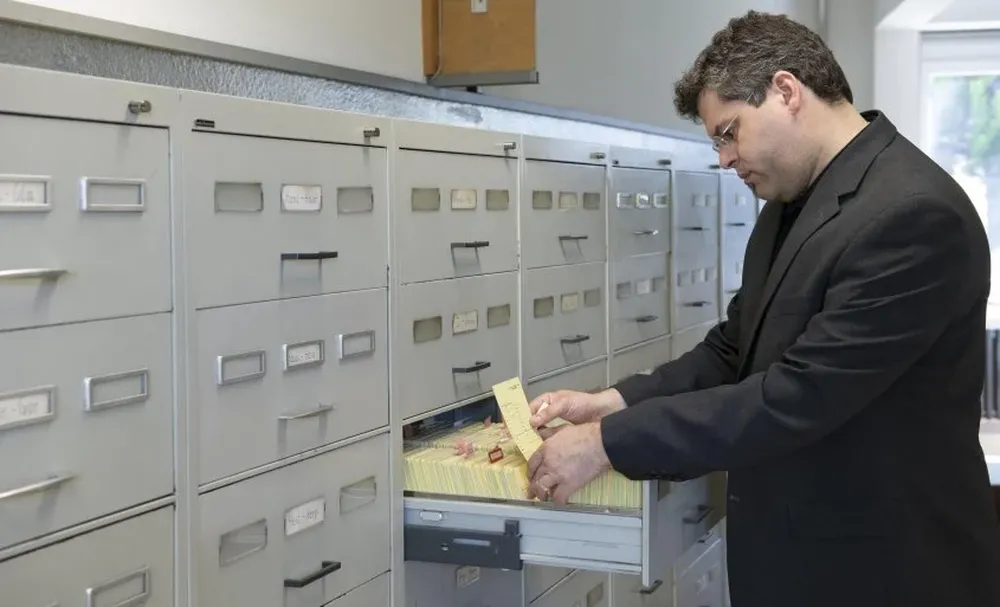Jens Rommel, jefe de la Oficina Central de las Autoridades Judiciales de los Estados Federales para la Investigación de Crímenes Nacionales Socialistas revisa las fichas en la sala de archivos de la institución