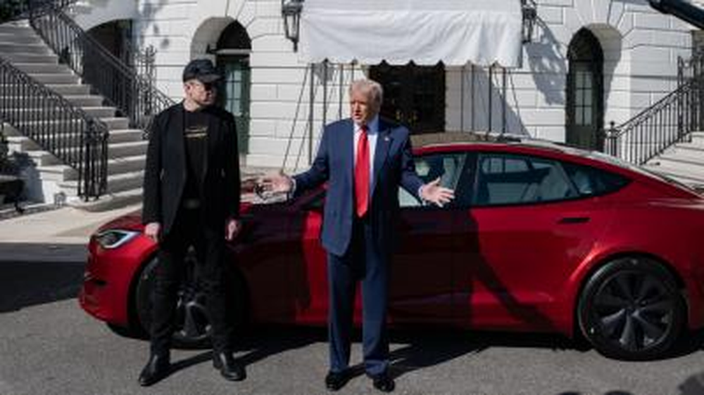 Elon Musk junto a Donald Trump frente a un Tesla.