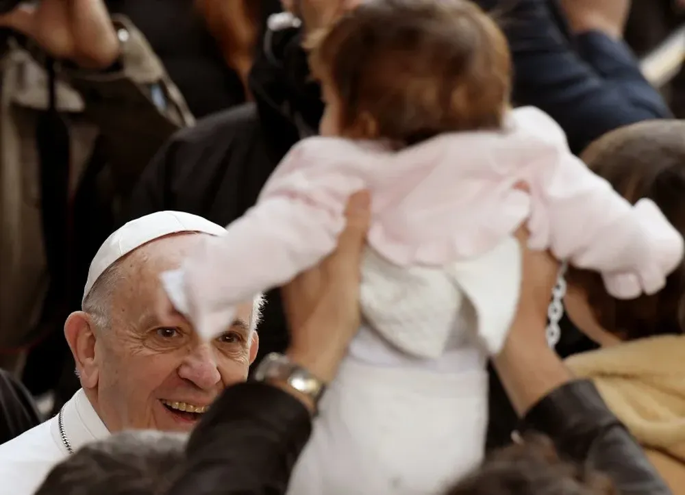 El Papa Francisco le sonríe a un bebé durante una reunión con estudiantes y profesores en Roma