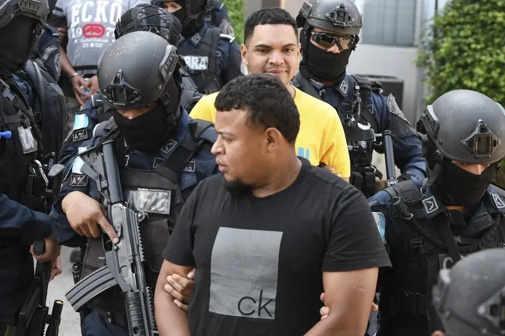 Mayer Banegas Medina es escoltado por fuerzas especiales de la policía hondureña luego de su detención este viernes.