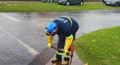 Trabajador municipal limpiando boca de tormenta