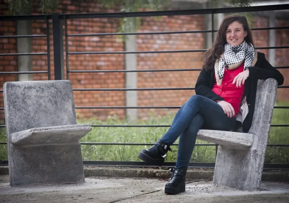 Sofía Orellano sentada en un mobiliario de Mento en el Liceo Nº61 Villa Cósmopolis, del Cerro
