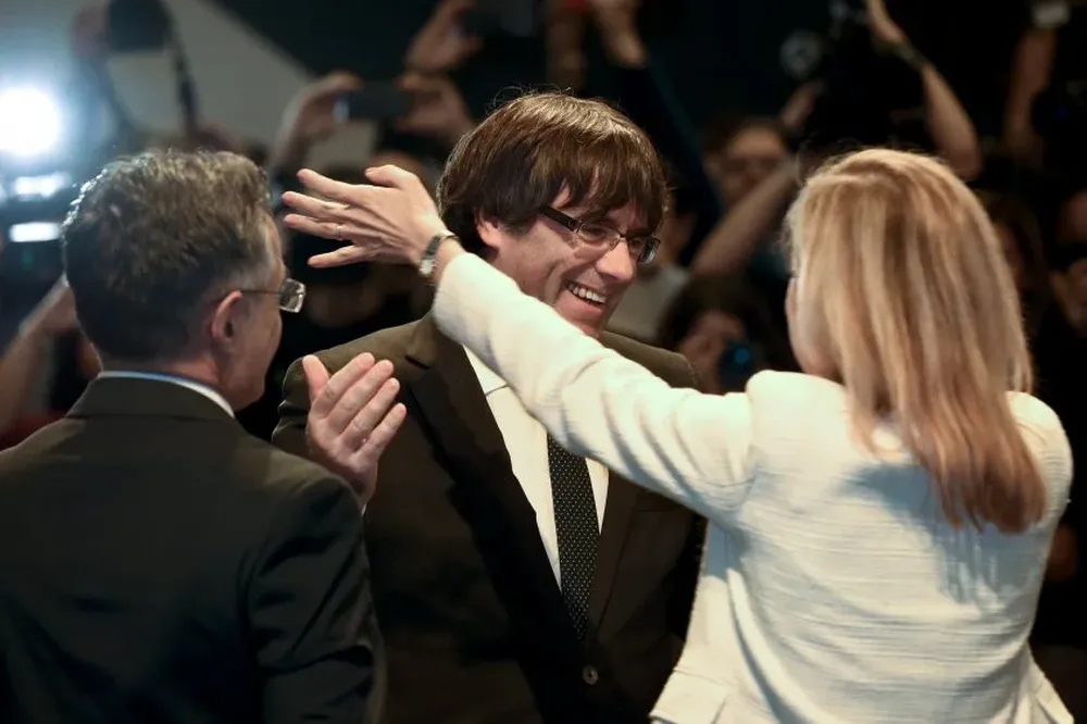 El presidente catalán destituido, Carles Puigdemont, abraza a una mujer en una reunión en Bruselas