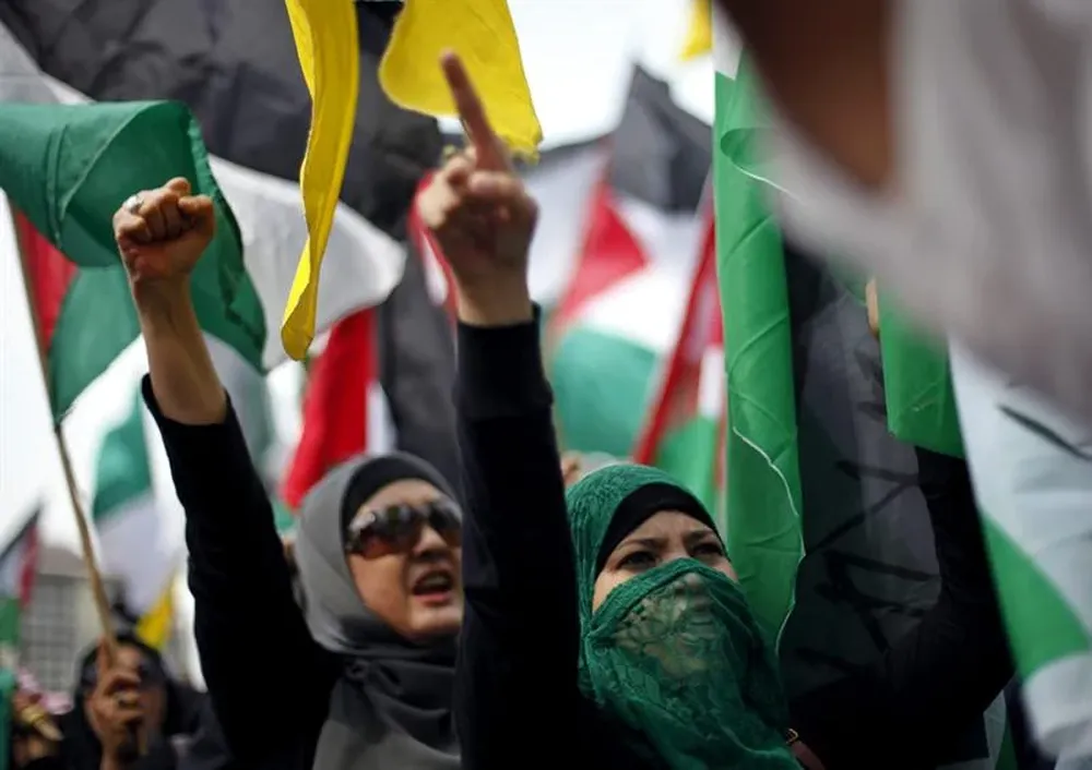 Varias mujeres indonesias levantan los puños mientras corean consignas durante una manifestación contra Israel