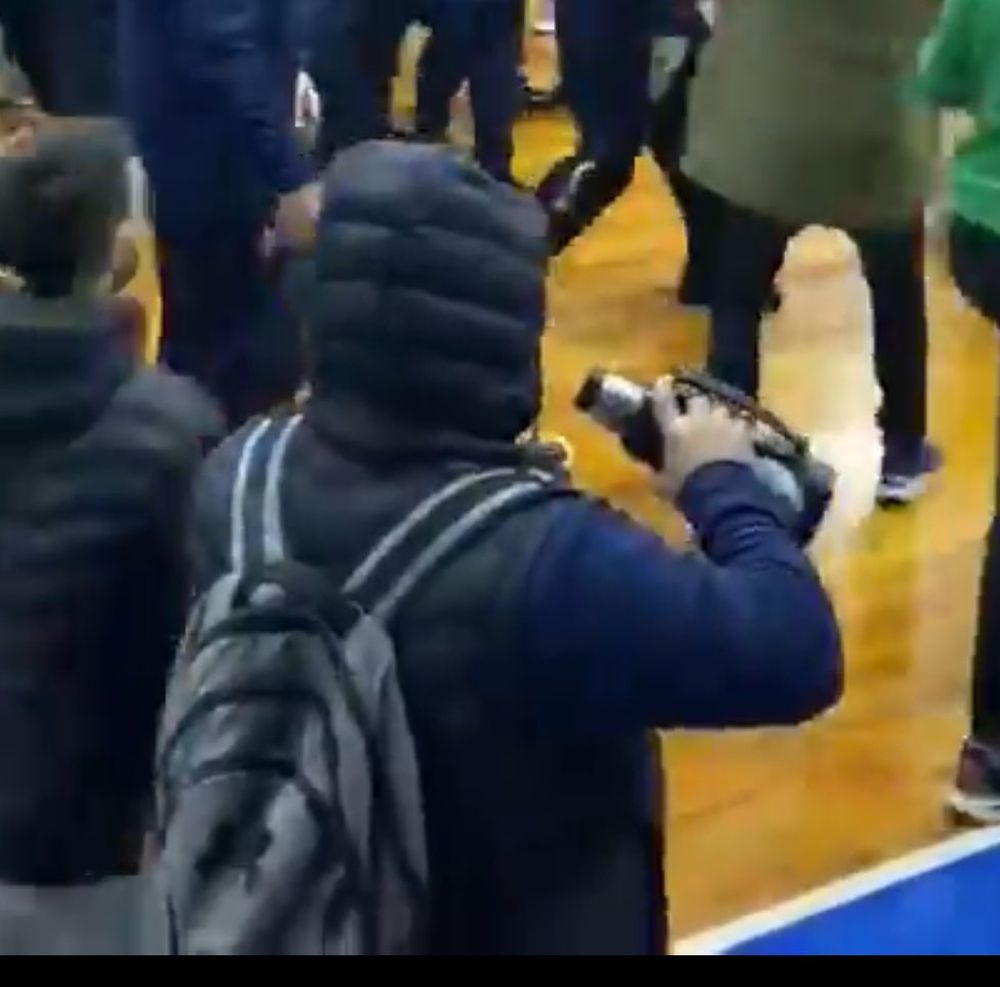 Un hincha toma mate mientras mira la trifulca entre Sayago y Unión Atlética