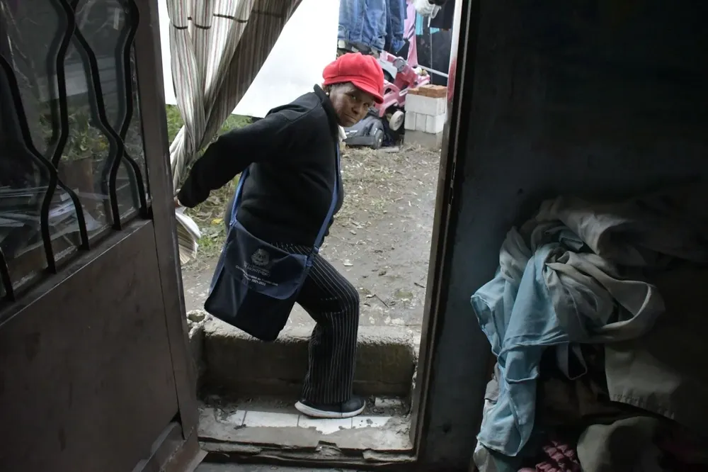 Olga Acosta, entrando a su antigua casa, que tenía un murito en la puerta para que no entrara el agua cuando subía la cañada. 
