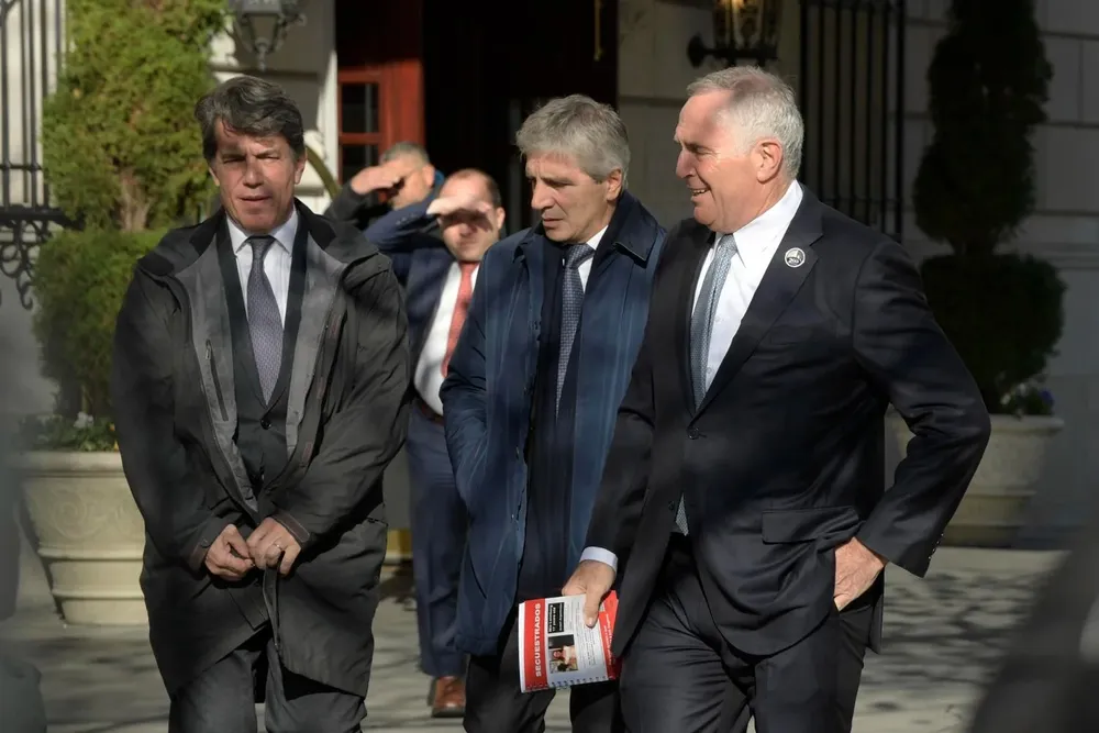 El embajador de Argentina en EE.UU., Mark Stanley (d); y los asesores del presidente electo argentino, Javier Milei, Luis Caputo (c) y Nicolas Posse (i)