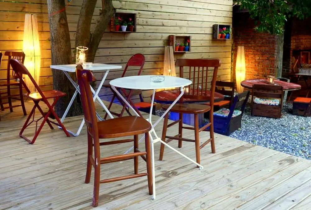 Parte del fondo y mesas sobre la tarima contigua al parrillero