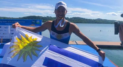 Felipe Klüver festejando con la medalla y con la bandera uruguaya