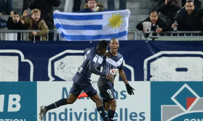 Diego Rolan celebra con la bandera uruguaya de fondo