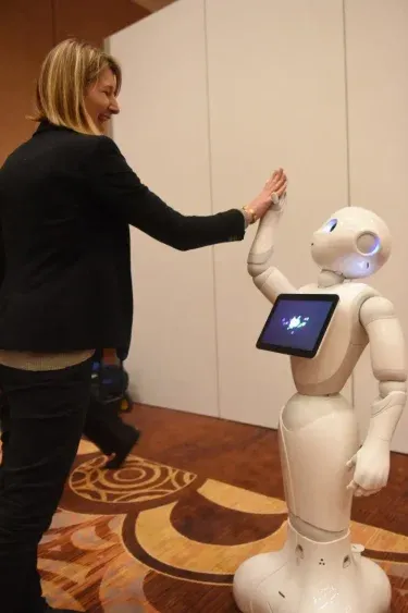 Pepper, un robot humanoide japonés, le choca los cinco a una visitante del CES 2016