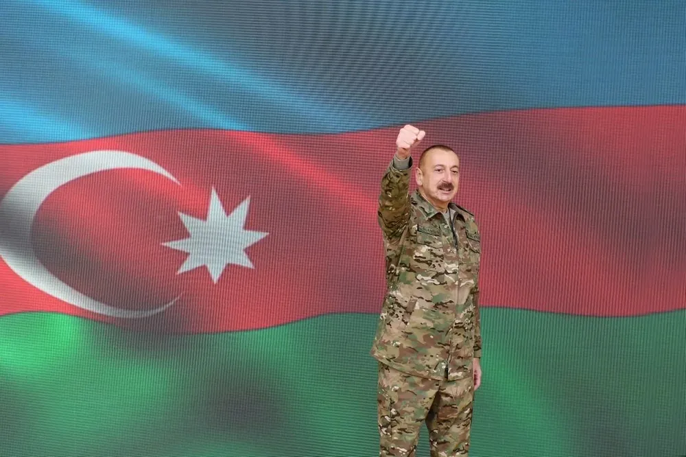 Ilham Aliyev, vestido con traje militar y levantando el puño, anuncia durante un discurso televisado a la nación la reconquista de Nagorno-Karabaj.