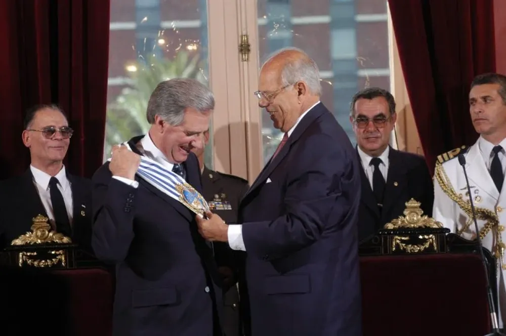 El presidente saliente Jorge Batlle hace entrega de la banda presidencial al flamante presidente de la República Tabaré Vázquez. Es la primera vez en la historia que de la fuerza de izquierda surge del mandato electoral el presidente.