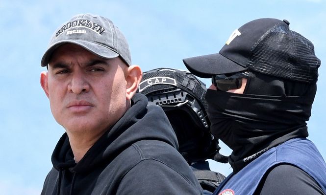 El presunto narcotraficante hondureño Mario José Calix, alias El Cubeta, es escoltado por miembros de la Dirección Nacional de Fuerzas Especiales (Cobras) durante su extradición a Estados Unidos en la base de Palmerola en Comayagua, a 50 km al norte de Tegucigalpa, el 4 de septiembre de 2024.