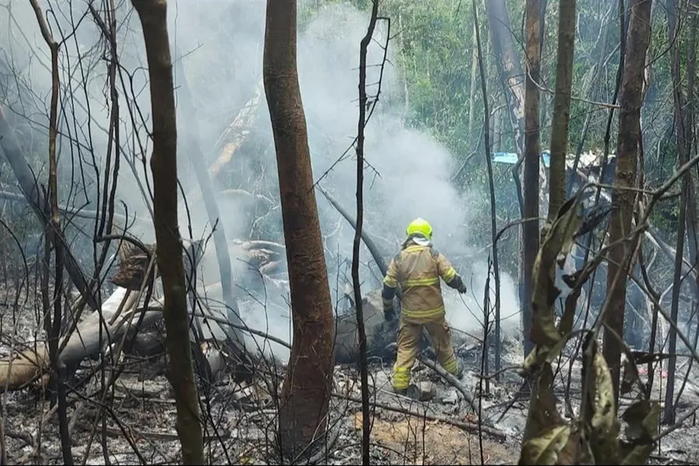 Bomberos y rescatistas trabajan en el lugar del accidente donde murieron diez pasajeros y los dos pilotos de un avión