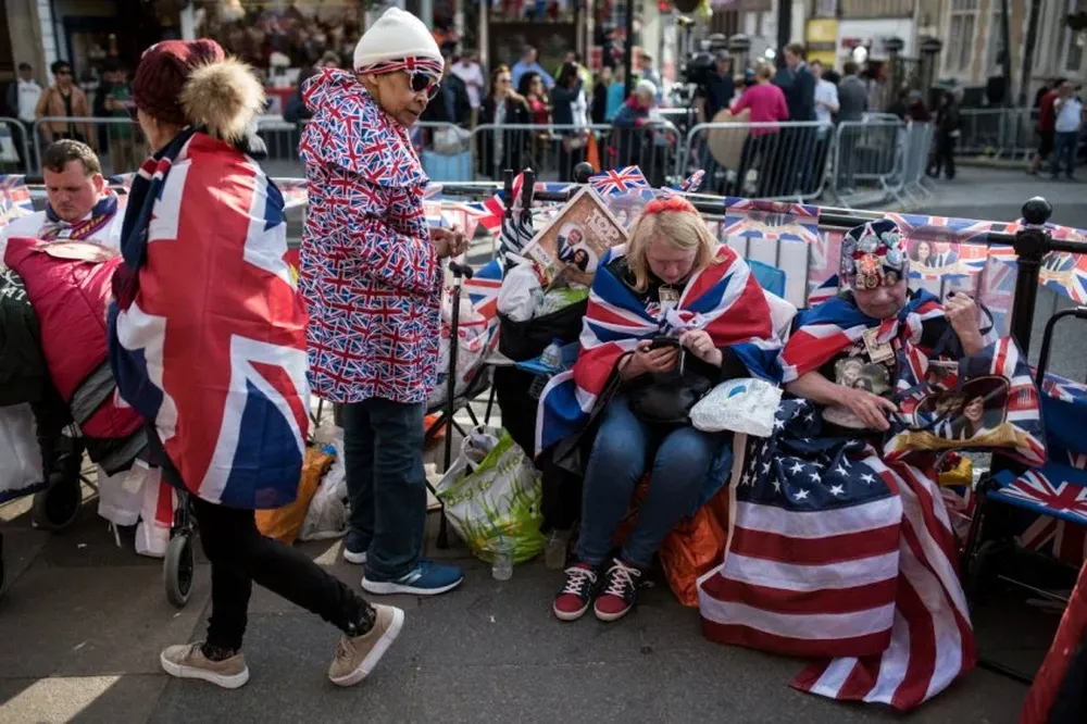 Un patriota británico flamea su bandera con la pareja de novios.