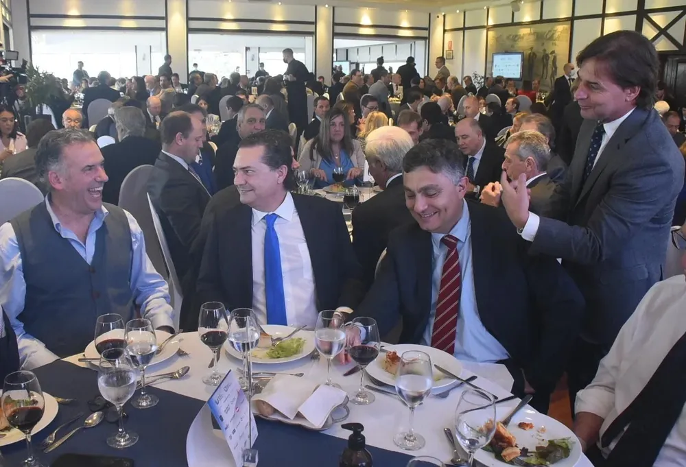 Luis Lacalle Pou (derecha), conversa con Yamandú Orsi (izquierda), con Rodrigo Ferrés e Isaac Alfie en medio, en el Día del Exportador