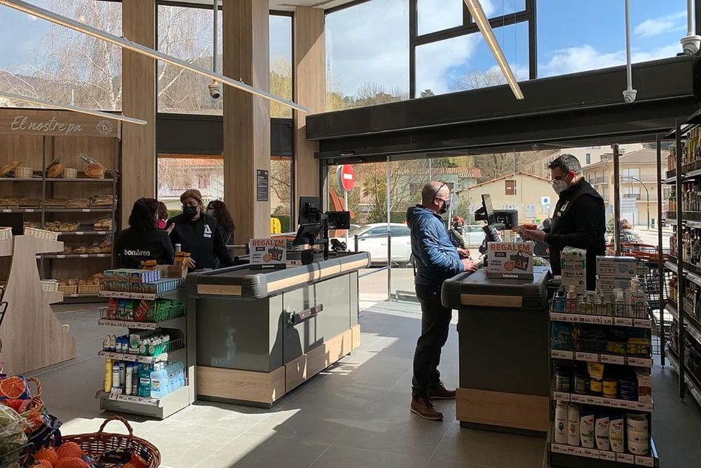 Clientes pagando en una gran superficie.