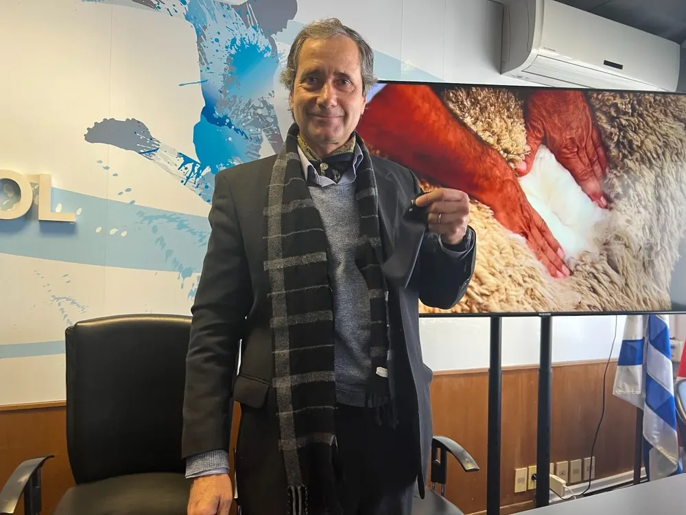 Alberto Bozzo muestra la tela con la que se harán los trajes de la delegación uruguaya que irá a Qatar.