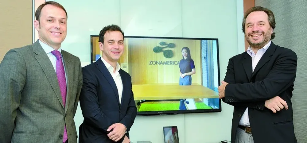Javier Bahut Vega, Martín Pérez y Jaime Miller; en la pantalla, Esmeralda, asistente del equipo de Zonamerica en China