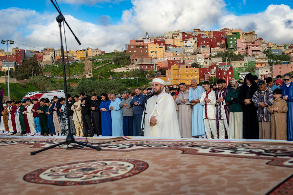 El Imán dirige la oración colectiva con motivo de la festividad del Aíd al-Fitr, en la explanada de Loma Colmenar en Ceuta.