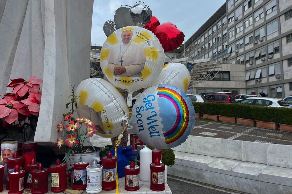 Velas y globos frente al hospital Gemelli de Roma donde permanece internado el Papa Francisco