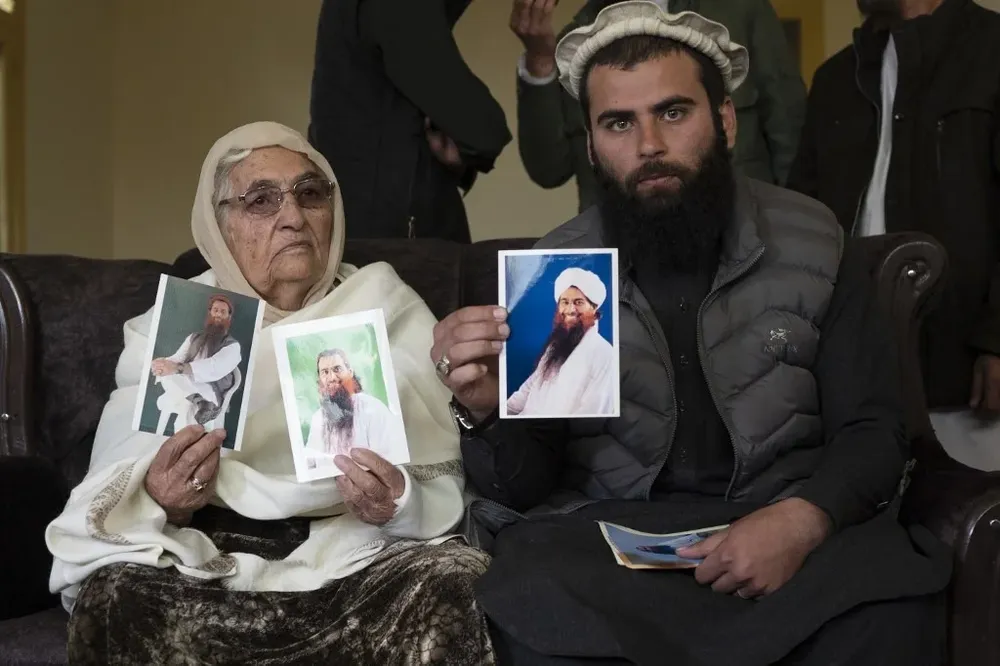 Safoora Bibi, su madre, y Muhammad Ismail, su hijo, muestran fotos del detenido Mohamed Rahim.