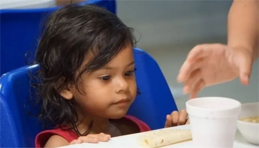 Una niña mira un vaso de sopa en un centro de detención de inmigrantes en la ciudad fronteriza de McAllen, en Texas.