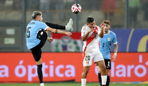 Edison Flores de Perú disputa un balón con Federico Valverde de Uruguay   