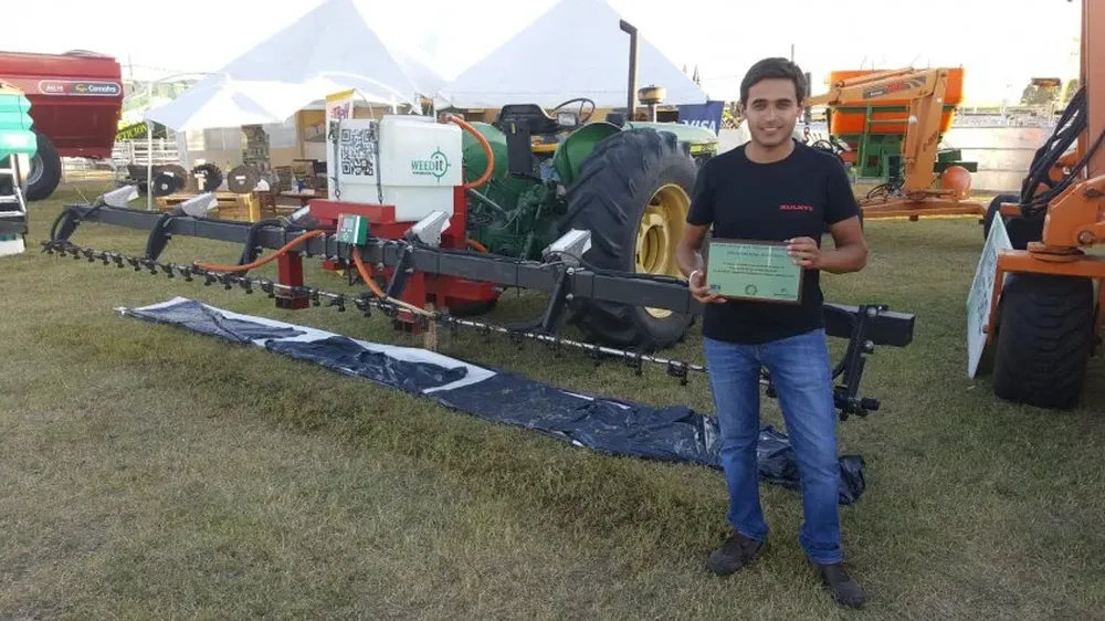 Uno de los técnicos de Marco Natural exhibe el premio delante del sistema distinguido.