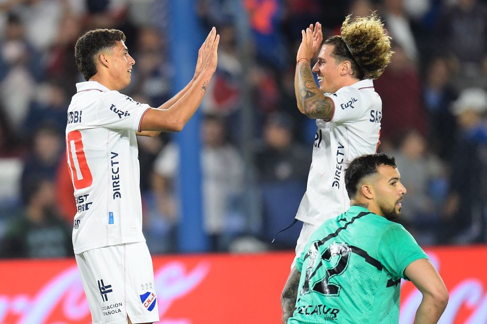 Baltasar Barcia y Luciano Boggio de Nacional se abrazan ante el desconsuelo del arquero de Cerro Largo, Pedro González, por el Torneo Apertura