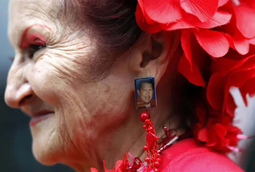 Venezuela- Una mujer usa fotografía de Hugo Chávez como arete durante una marcha en Caracas