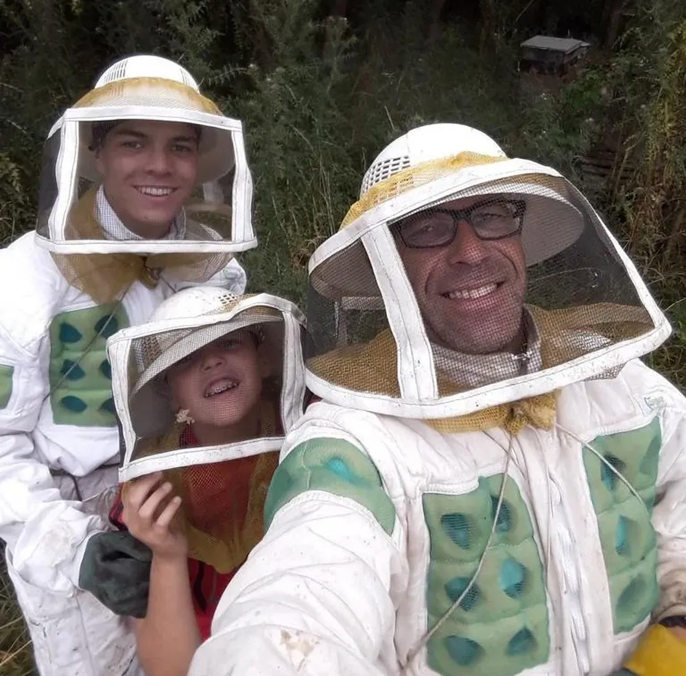 Carlos y sus hijos en uno de los colmenares que maneja.