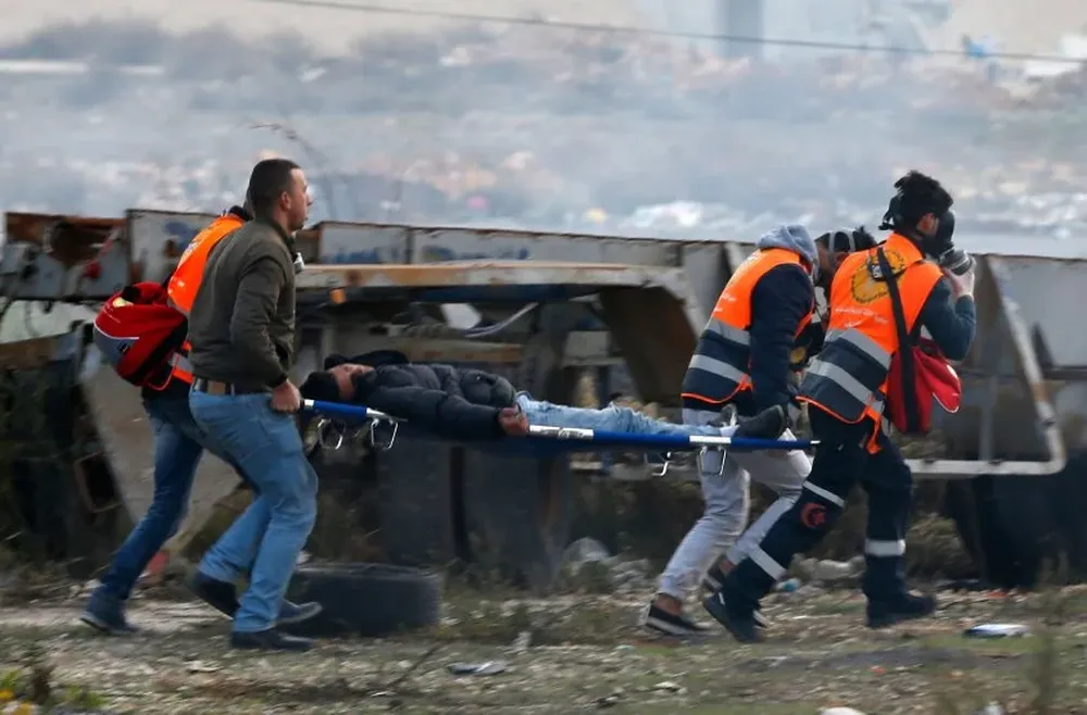 Servicios de emergencia palestinos rescatan un herido durante las protestas de hoy.