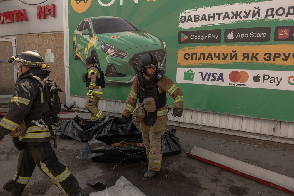 El personal de emergencia y rescate ucraniano camina junto a las bolsas para cadáveres que contienen los restos de las víctimas que murieron tras un ataque ruso a un supermercado, en Kostyantynivka, región oriental de Donetsk, el 9 de agosto de 2024, en medio de la invasión rusa de Ucrania.