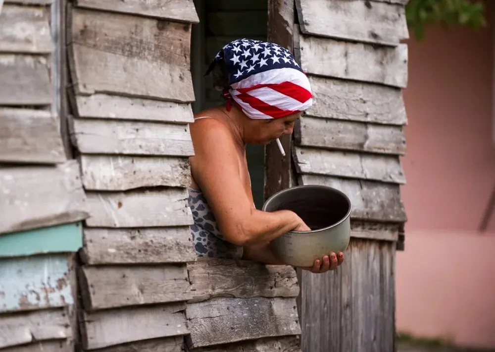 Cuba. Una mujer cubana usa una bandana con la bandera de Estados Unidos mientras trabaja en su casa de la Habana