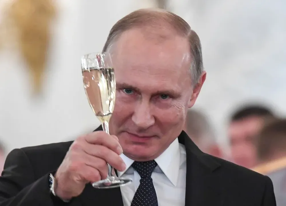 Russian President Vladimir Putin toasts with attendees after a ceremony to bestow state awards on military personnel who fought in Syria, at the Kremlin in Moscow on December 28, 2017. / AFP / POOL / Kirill KUDRYAVTSEV
