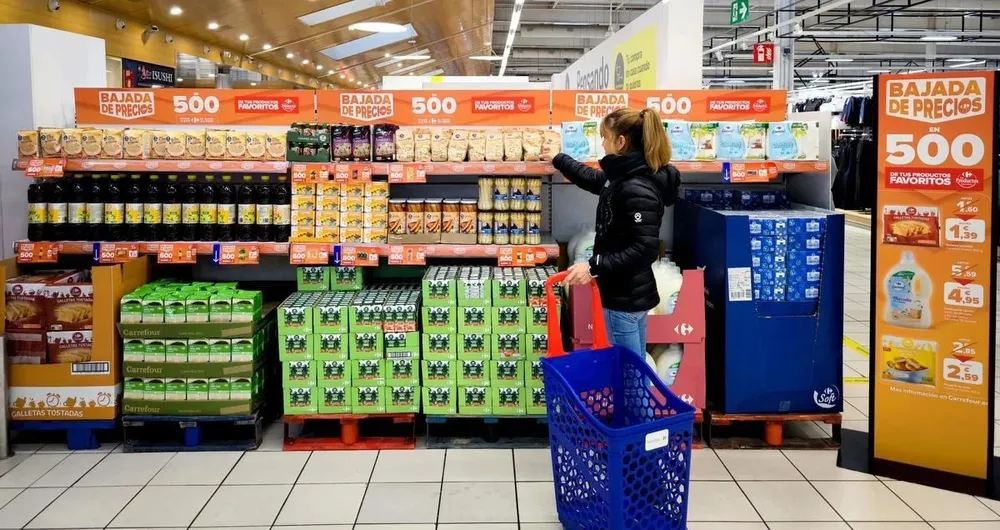 Una clientea compra en una de las estanterías con productos rebajados de Carrefour